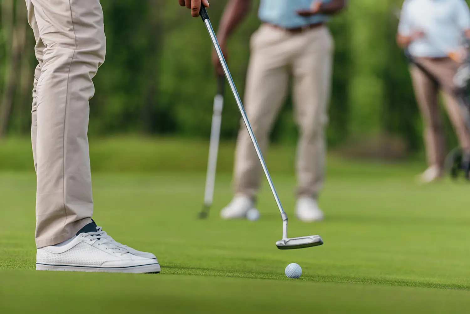 Golfer met putter bij een bal op de green